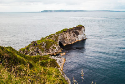 High angle view of rock formations by sea against sky