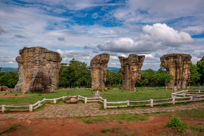 View of tourists on landscape against cloudy sky