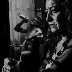 Portrait of woman drinking glass at home