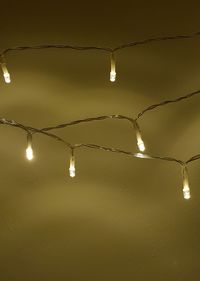 Low angle view of illuminated light bulbs hanging from ceiling