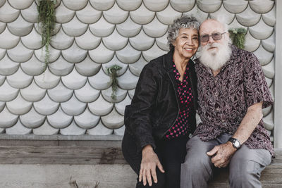 Portrait of active senior couple sitting and smiling outside