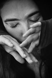 High angle close-up of woman with closed eyes covering face