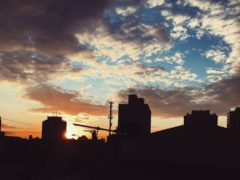 Silhouette city against sky during sunset
