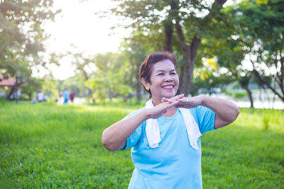 Woman exercising on field in park