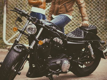 Low section of man standing on motorcycle