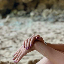 Cropped hand of woman on beach