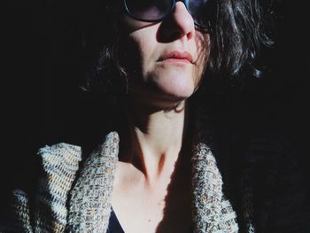 Close-up portrait of woman against black background