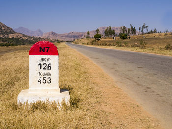 Information sign on road against sky