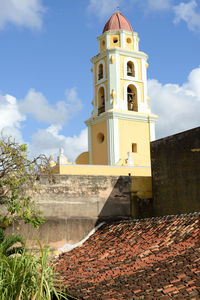 Low angle view of bell tower amidst buildings against sky