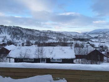 Houses on snowcapped mountains against sky