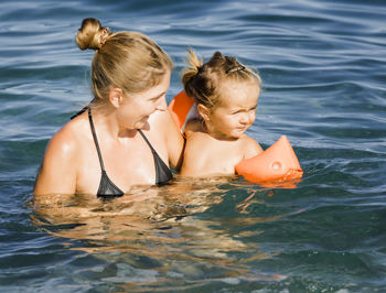 Mother and daughter in water