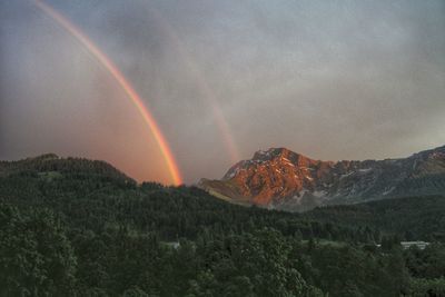 Scenic view of rainbow over mountains against sky