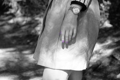 Midsection of woman with purple nail polish in park