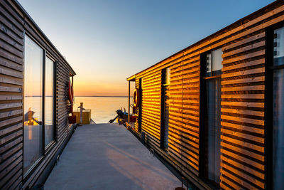 Buildings by sea against clear sky during sunset