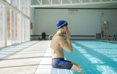 Rear view of man standing in swimming pool