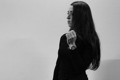 Woman with long hair standing against wall