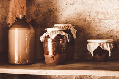 Close-up of jar on table against wall