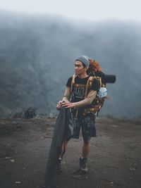 Full length portrait of man standing on mountain