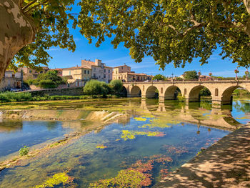 Arch bridge over river against sky