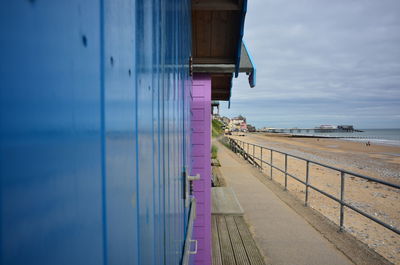 Pier on sea by buildings against sky