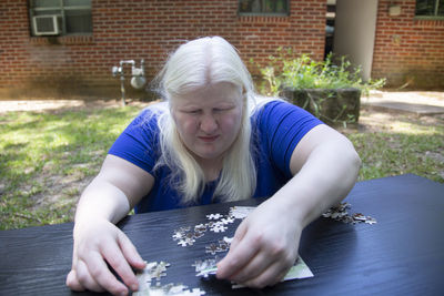 Woman placing a puzzle piece into the correct spot