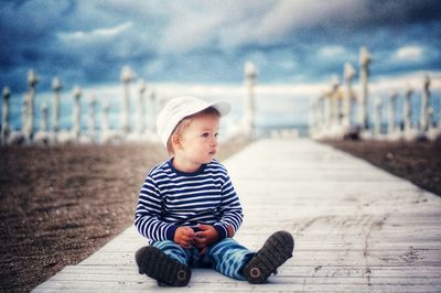 Cute boy on the beach with dramatic sky