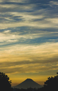 Low angle view of silhouette mountain against dramatic sky