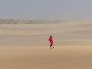 Full length of woman walking on sand dune