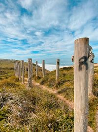 Wooden fence on field against sky