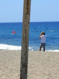 Full length of man on beach against clear sky