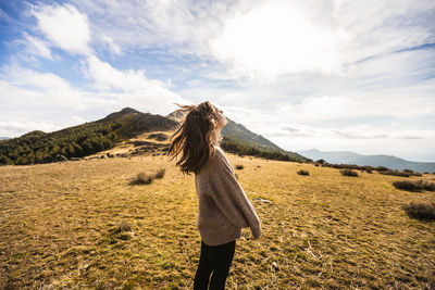 Full length of woman standing on field against sky