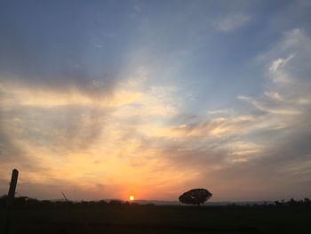 Scenic view of silhouette field against sky during sunset