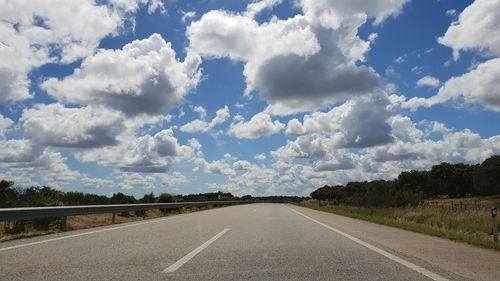 Empty road along landscape against sky