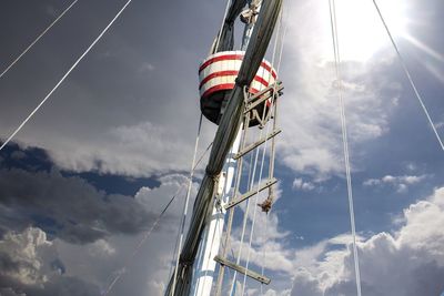 Low angle view of mast against cloudy sky