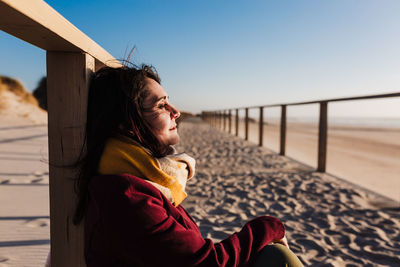 Young woman with eyes closed relaxing at beach at sunset. holidays and relaxation concept