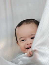 Close-up of cute baby boy lying in a hammock at home