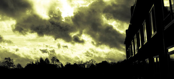 Low angle view of silhouette trees against sky