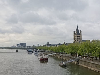 Boats in river against buildings in city