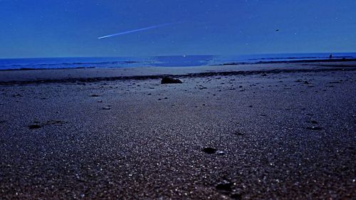 Scenic view of beach against blue sky