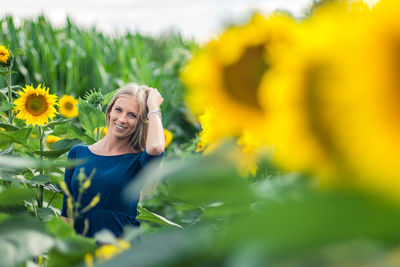 Portrait of woman with sunflower in field