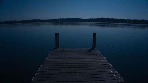 Pier over lake against blue sky