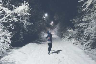 Rear view of woman walking on snow during winter