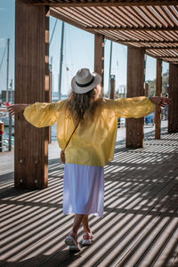 Rear view of woman standing by umbrella