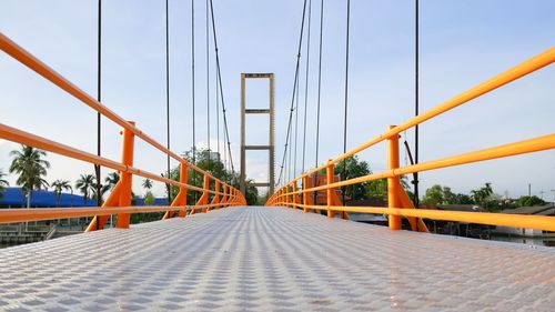 Surface level of suspension bridge against sky