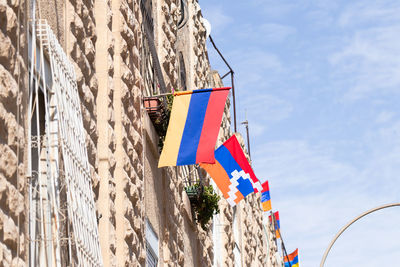 Low angle view of flags hanging against sky