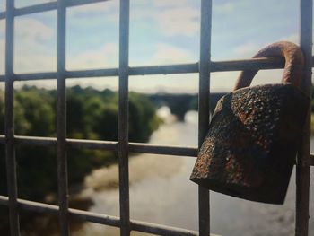 Close-up of metal grate against sky