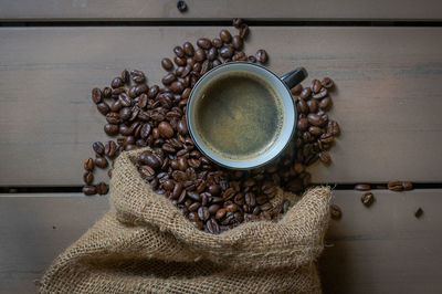 High angle view of cup of coffee and coffee beans