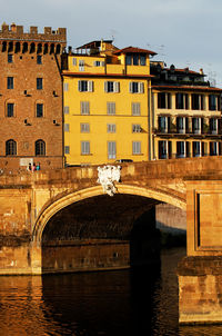 Ponte santa trinita over arno river in tuscany against sky