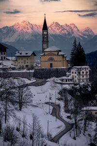 Church by buildings against sky during winter