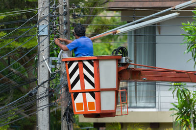 Man with arms outstretched against built structure